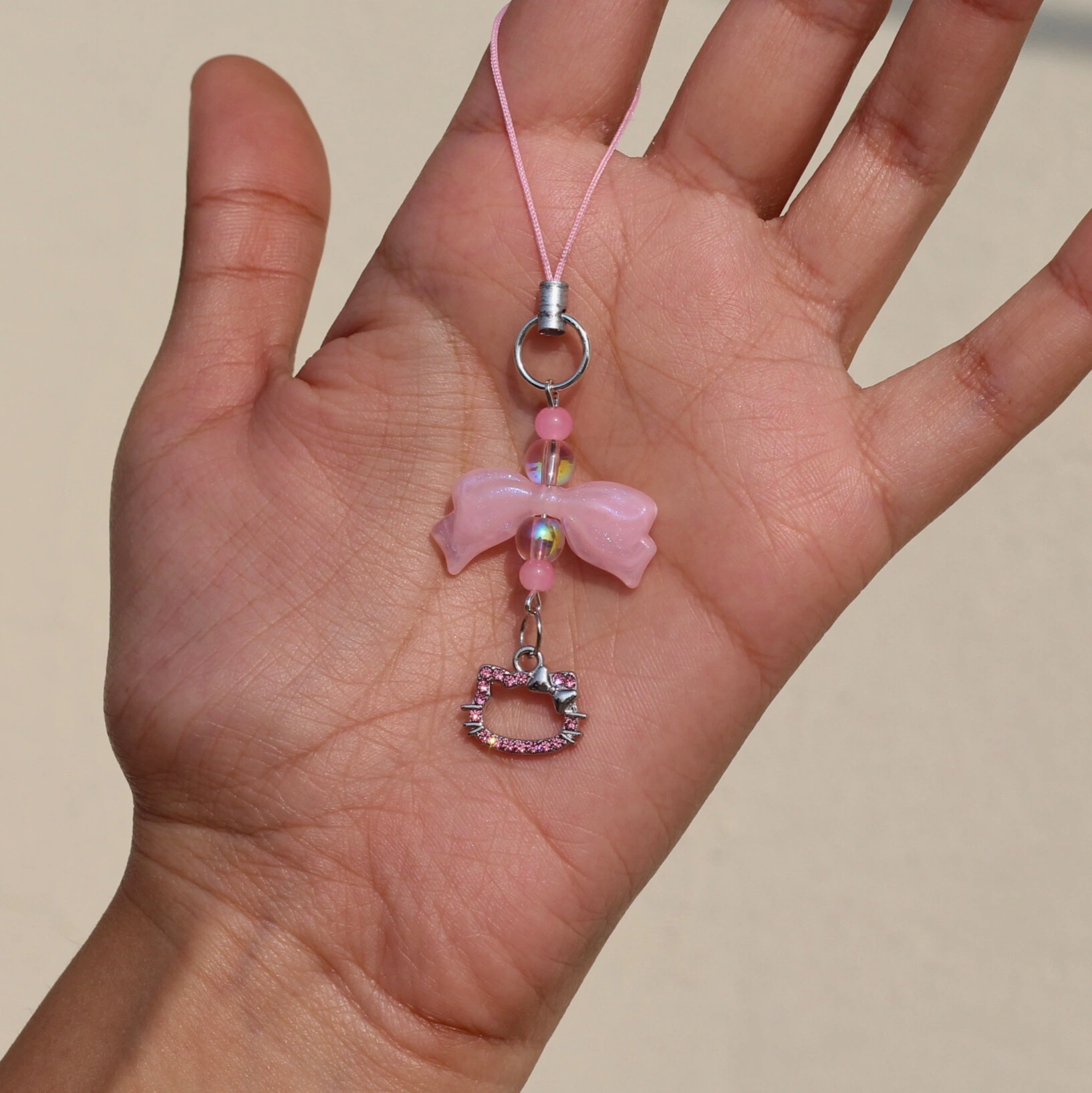 Hello Kitty Pink Rhinestone Phone Charm in the Hand Overview Image